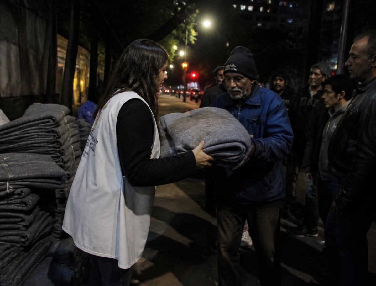 Entrega de cobertores em uma noite fria na rua